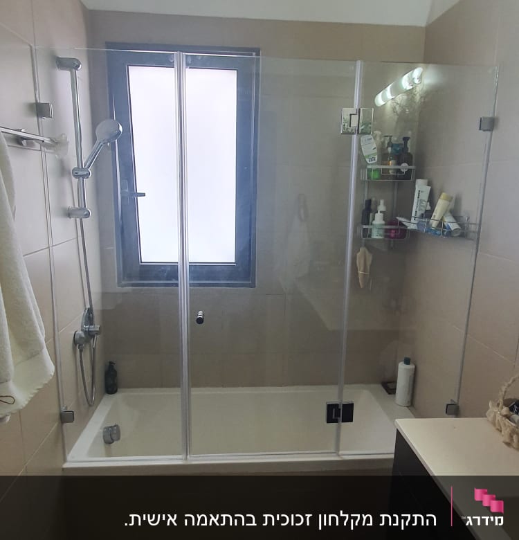 מקלחת עם דלת זכוכית, מדף עם מוצרי טיפוח